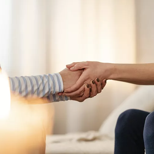 Deux personnes se tenant la main en signe de soutien