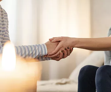 Deux personnes se tenant la main en signe de soutien