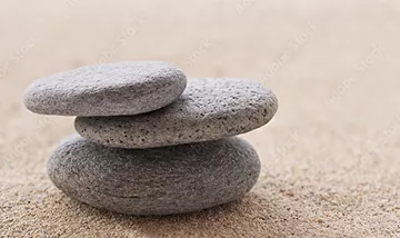 Galets empilés sur le sable, symbole d’équilibre